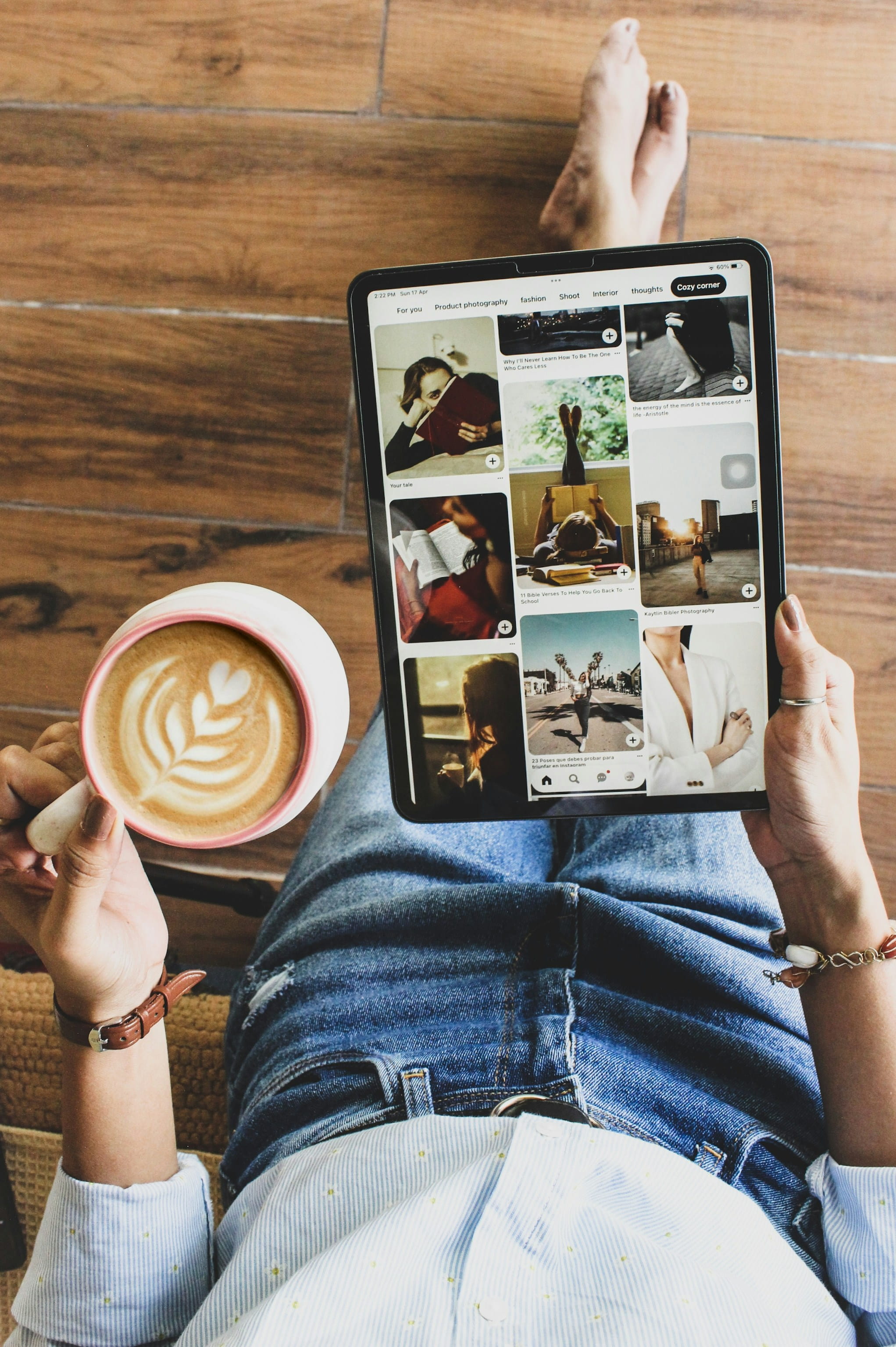 A reader browsing a grid of digital content on a tablet over coffee