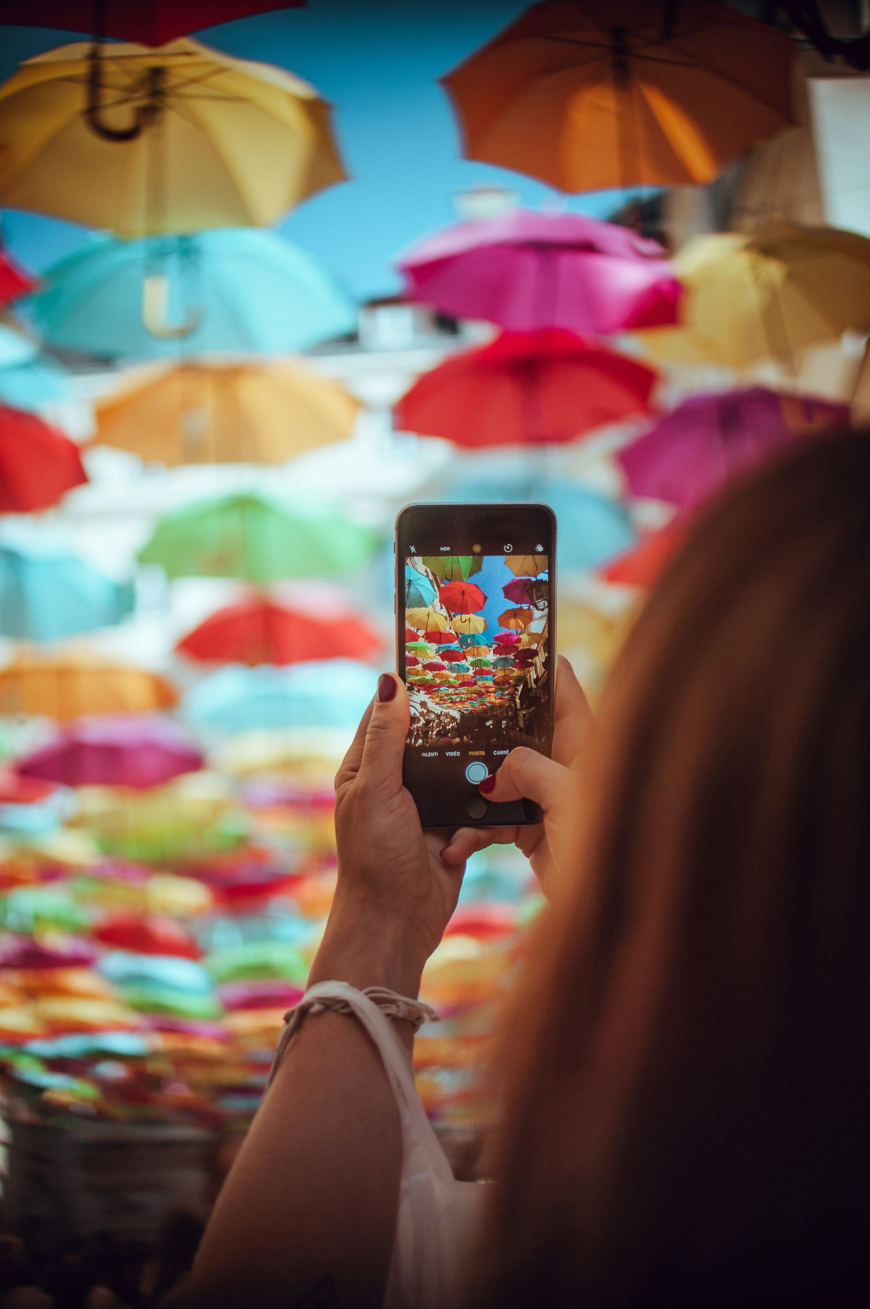 A creator photographing a vibrant display of colourful street umbrellas