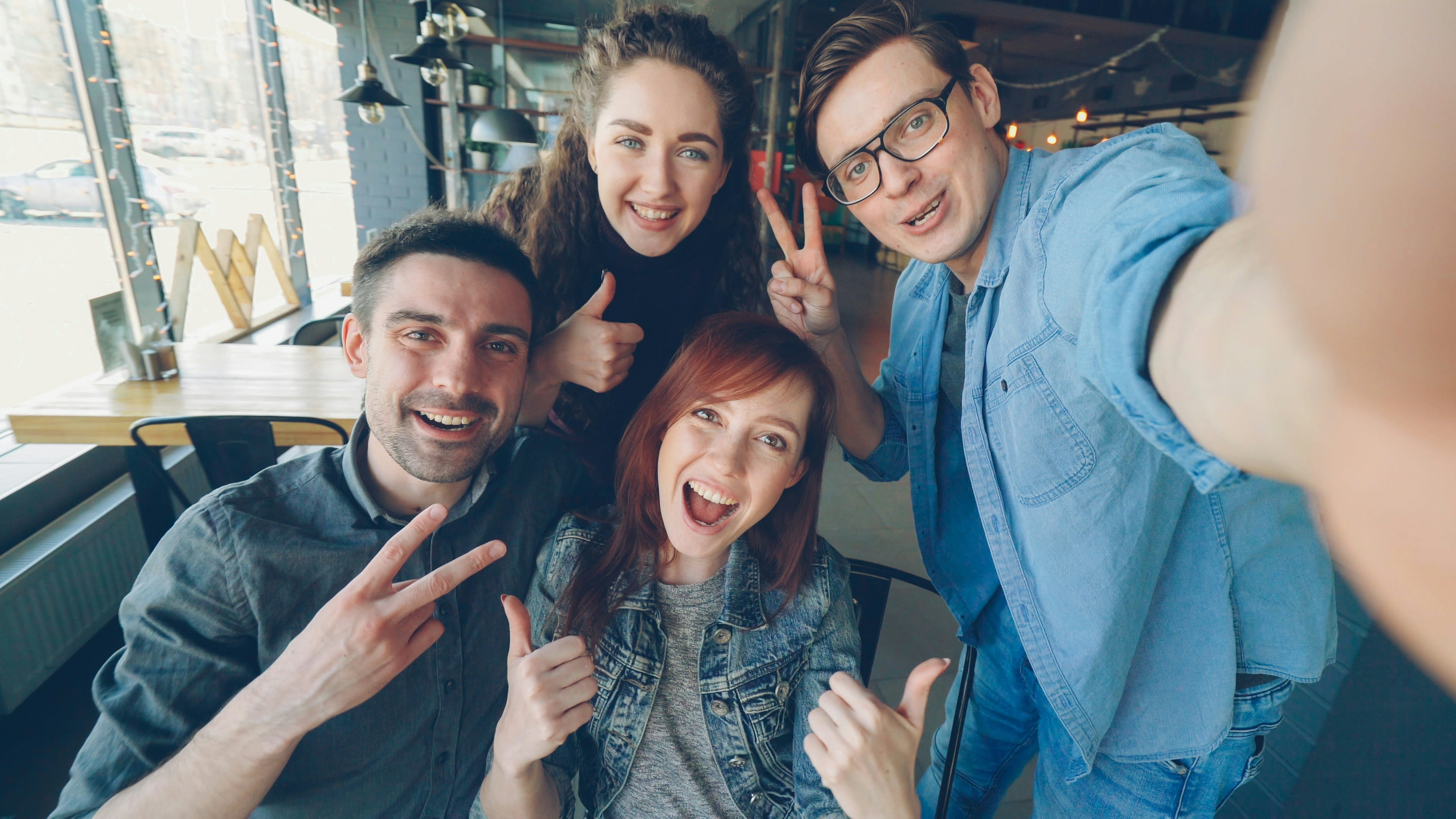 A group of friends taking a selfie together in a cosy cafe