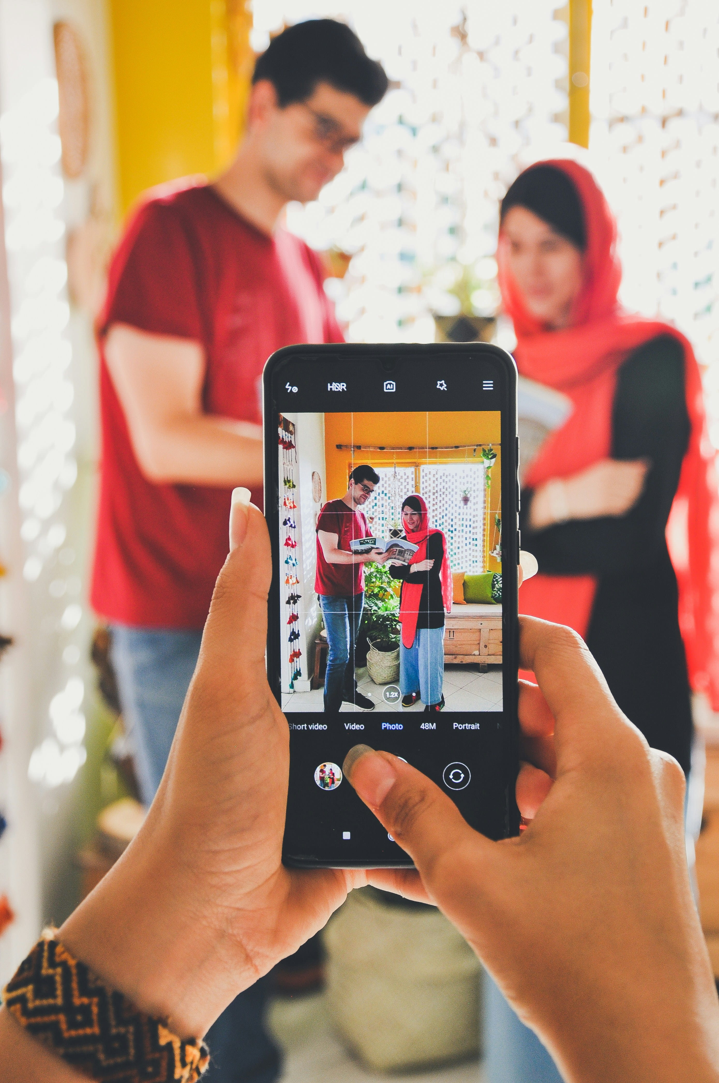 A shopper photographing a couple in a colourful retail boutique